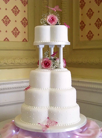 Clover shaped wedding cake and fresh flowers with butterflies