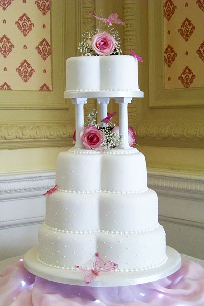 Clover shaped wedding cake fresh flowers with butterflies